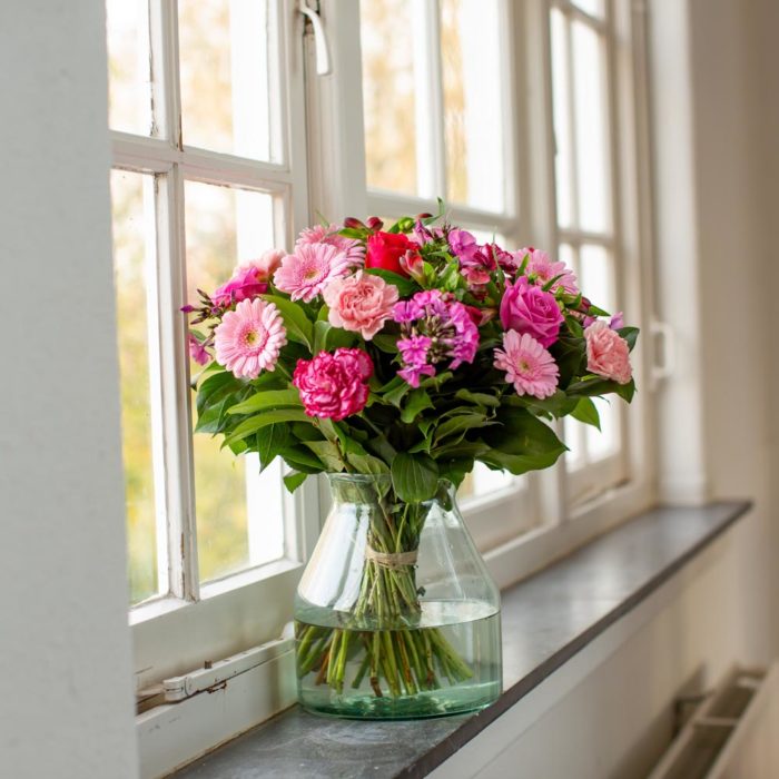 gerbera's en rozen in het raam